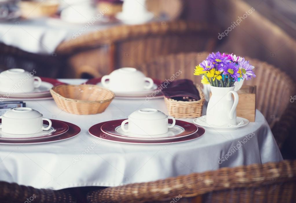 Table set for dinner in a restaurant or bistro with dinnerware a