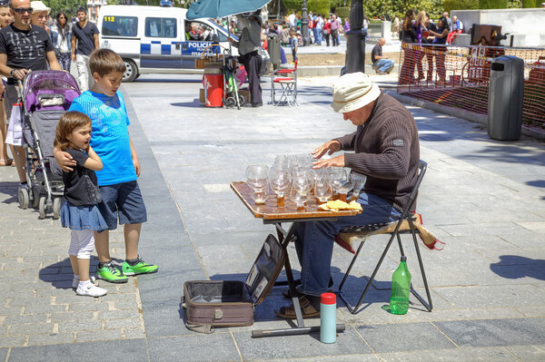 Музыкант играет на стеклянных бокалах с водой
