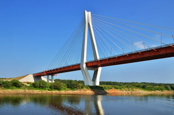 Eine große rot-weiße Brücke durch den Fluss — Stockfoto