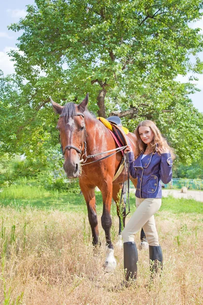 Young girl walking with a horse in the garden. — Stock Photo, Image