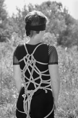 Elleri ile ilişkili kadın bağladılar ve gözü kapalı. Shibari.