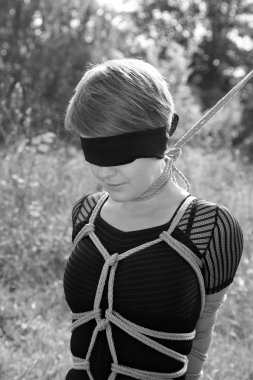 Kadınla bir ilmik boynuna bağlı. Shibari.