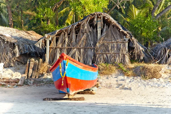パームの作られた伝統的な小屋の背景に漁船 — ストック写真