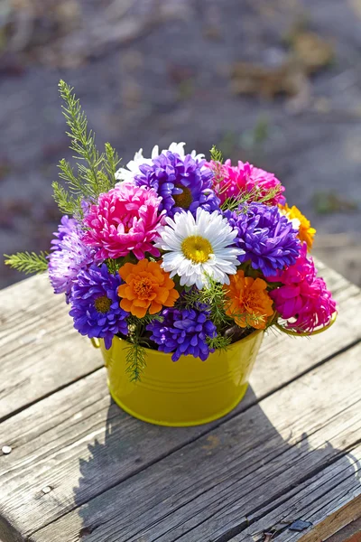 Chrysanthemum bouquet in a basket  on old wooden stool — Stock Photo, Image