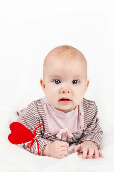 Little baby girl with red heart on a stick — Stock Photo, Image