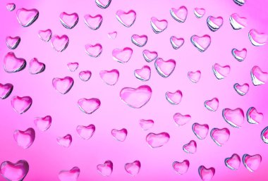 Su damlalarının kalpleriyle soyut pembe arkaplan.