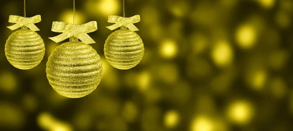 Drie kerstballen over abstracte achtergrond van onscherpe vakantielichten — Stockfoto