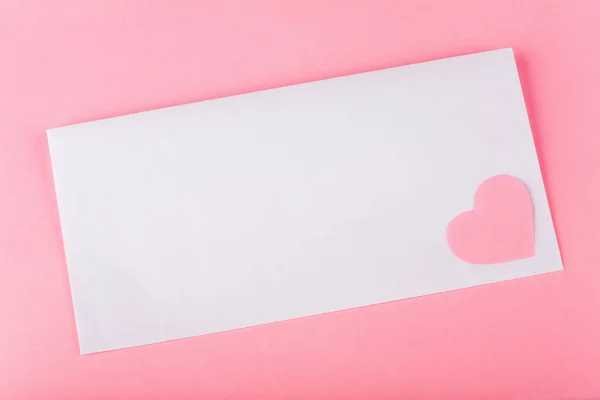 Weiße Hülle mit rosa Papierherz Stockbild
