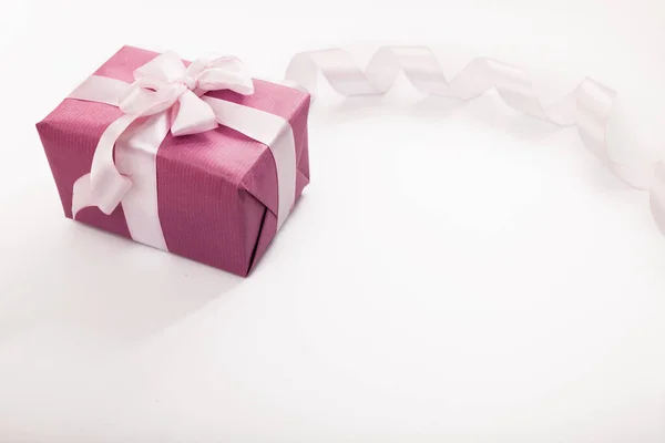 粉色礼品盒 白色蝴蝶结 长长的弯曲缎带 空白的白底文字空间 节日问候背景或请柬 复制空间 图库图片