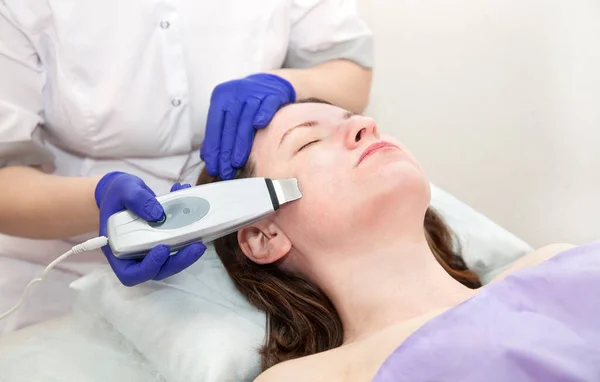 Femme caucasienne recevant un peeling facial ultrasonique avec un équipement professionnel dans le salon de spa. Cosmétologie et soins de la peau. Image En Vente