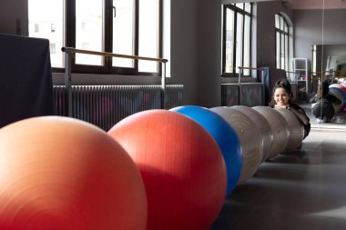 Ballerina posing with swiss balls before doing her daily routine.