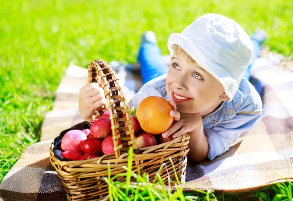 Jongen met fruit buiten — Stockfoto