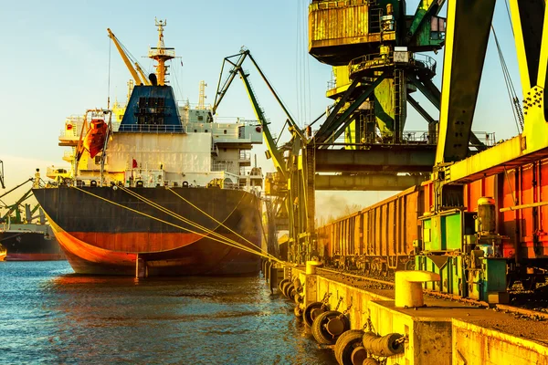 Průmyslová nákladní loď s pracuje jeřáb v přístavu — Stock fotografie