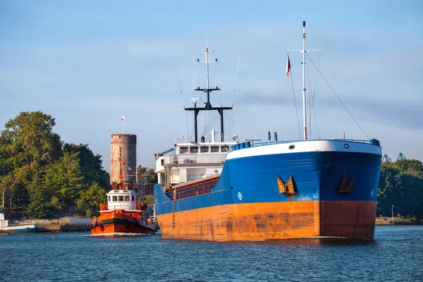 Cargo ship with tug boat — Stock Photo, Image