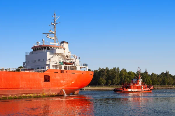 Cargo ship with tug boat — Stock Photo, Image