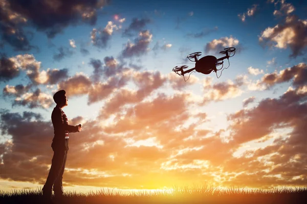 Man die een drone bij zonsondergang — Stockfoto