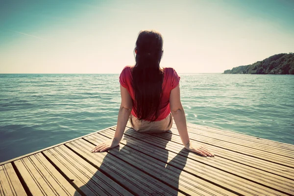 Young woman resting on jetty — Stock Photo, Image