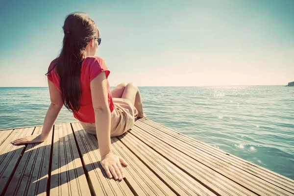 Giovane donna che riposa sul molo — Foto Stock