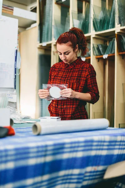 Woman worker packing products for shipment. Industry, manual work