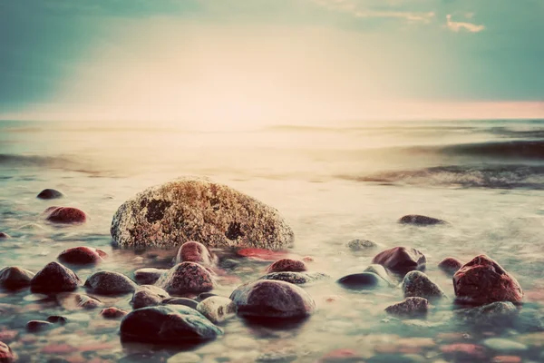 岩のビーチの劇的な夕日. — ストック写真