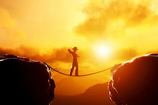 Man  balancing on rope over mountains — Stock Photo, Image