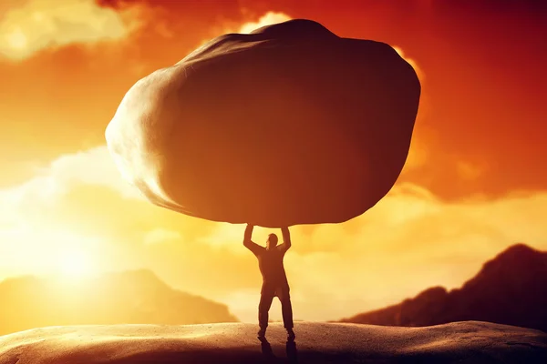 Man lifting a huge rock. — Stock Photo, Image