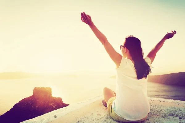 Young woman sits with hands up — Stock Photo, Image