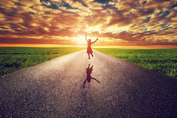 Mulher feliz pulando na estrada — Fotografia de Stock