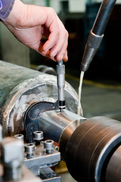 Medición del trabajador en la máquina de torneado industrial . — Foto de Stock