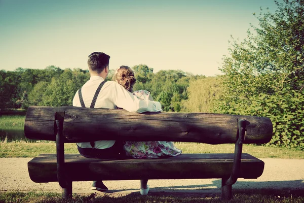 Jeune couple amoureux assis sur un banc — Photo