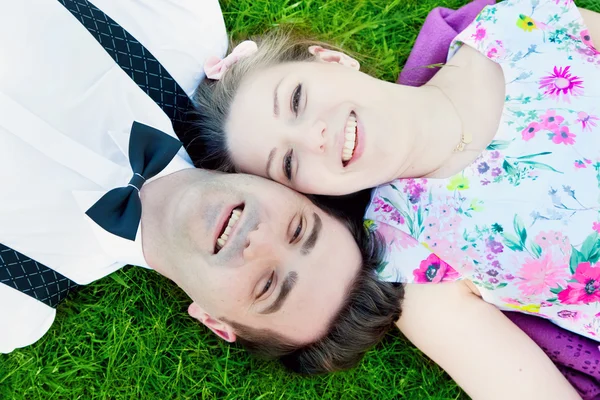 Happy couple in love lying on grass — Stock Photo, Image