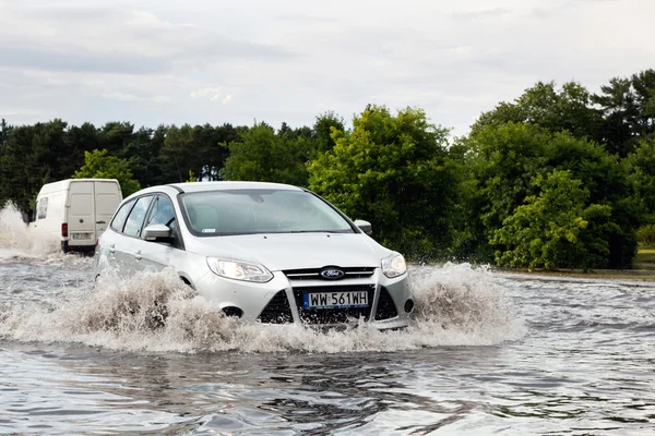 Cars trying to drive against flood — Stockfoto