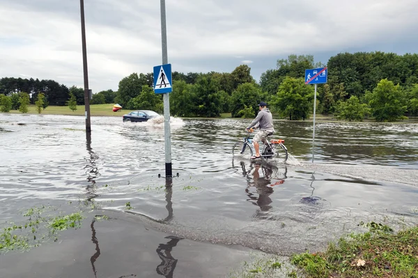 Man cycling and car trying — стокове фото