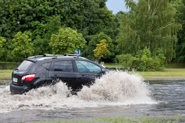 Coche tratando de conducir contra la inundación — Foto de Stock