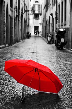 Red umbrella on cobblestone street clipart