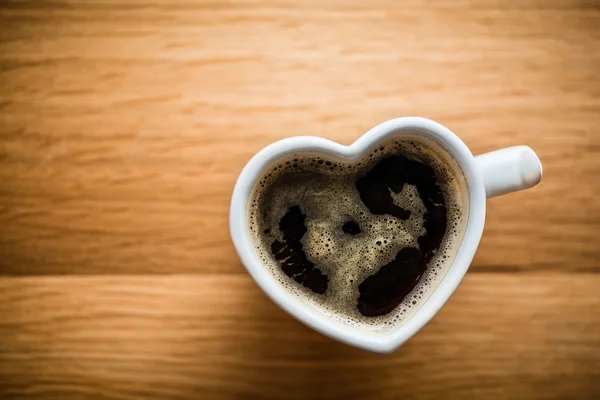 Coffee in heart shaped cup — Stock Photo, Image
