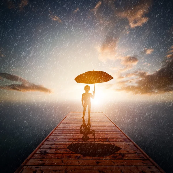 Дитина з парасолькою, що стоїть сама — стокове фото