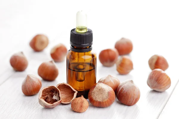Essential oil and hazelnuts — Stock Photo, Image