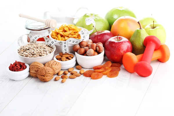 Fita métrica com halteres e frutas para o café da manhã — Fotografia de Stock