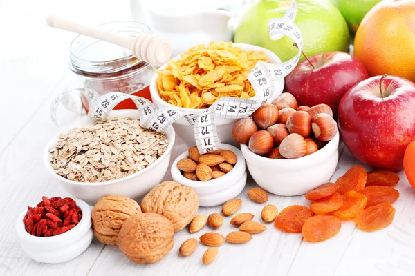 Measure tape with dumbbells and fruits for breakfast — Stock Photo, Image