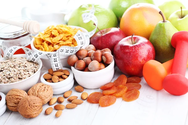 Fita métrica com halteres e frutas para o café da manhã — Fotografia de Stock