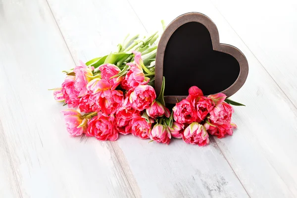 Lots of pink tulips with heart — Stock Photo, Image