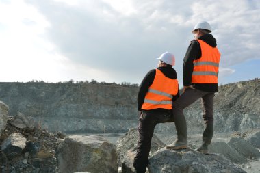 Two workers and quarry in background clipart