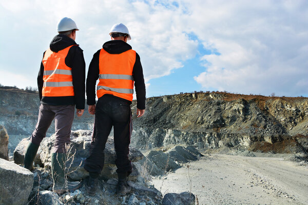 Two workers and quarry in background