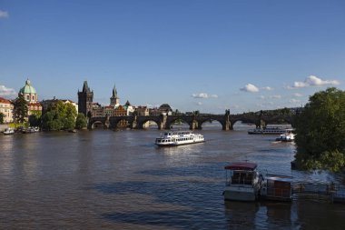 Çek Cumhuriyeti, Prag - 4 Temmuz 2013: Günbatımında turist gemileri ve Charles Köprüsü ile Vltava Nehri manzarası 