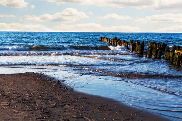 Una hermosa ola golpea la playa en una playa de arena en un día soleado. —  Fotos de Stock