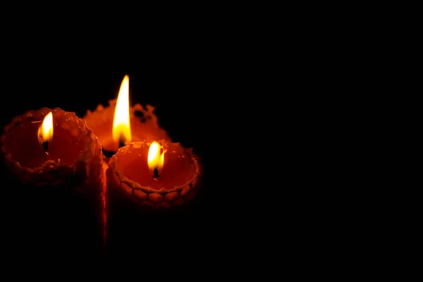 Close-up of three small yellow candles on a black background. — Stock Photo, Image