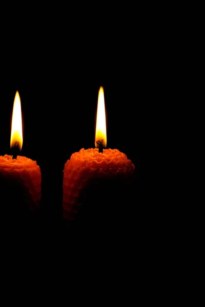 Close-up of two lit yellow candles on a black background. — Stock Photo, Image