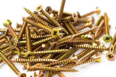 Beyaz bir arka planda sarı kendi kendine dokunan vida. Çok sayıda vida.