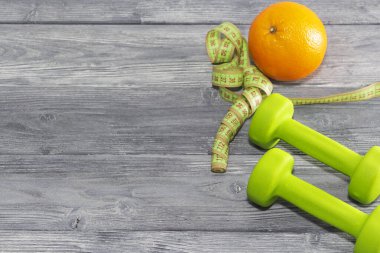 turuncu ve dambıl. Egzersiz, sağlıklı yaşam tarzı. Kilo kaybı için spor diyeti.